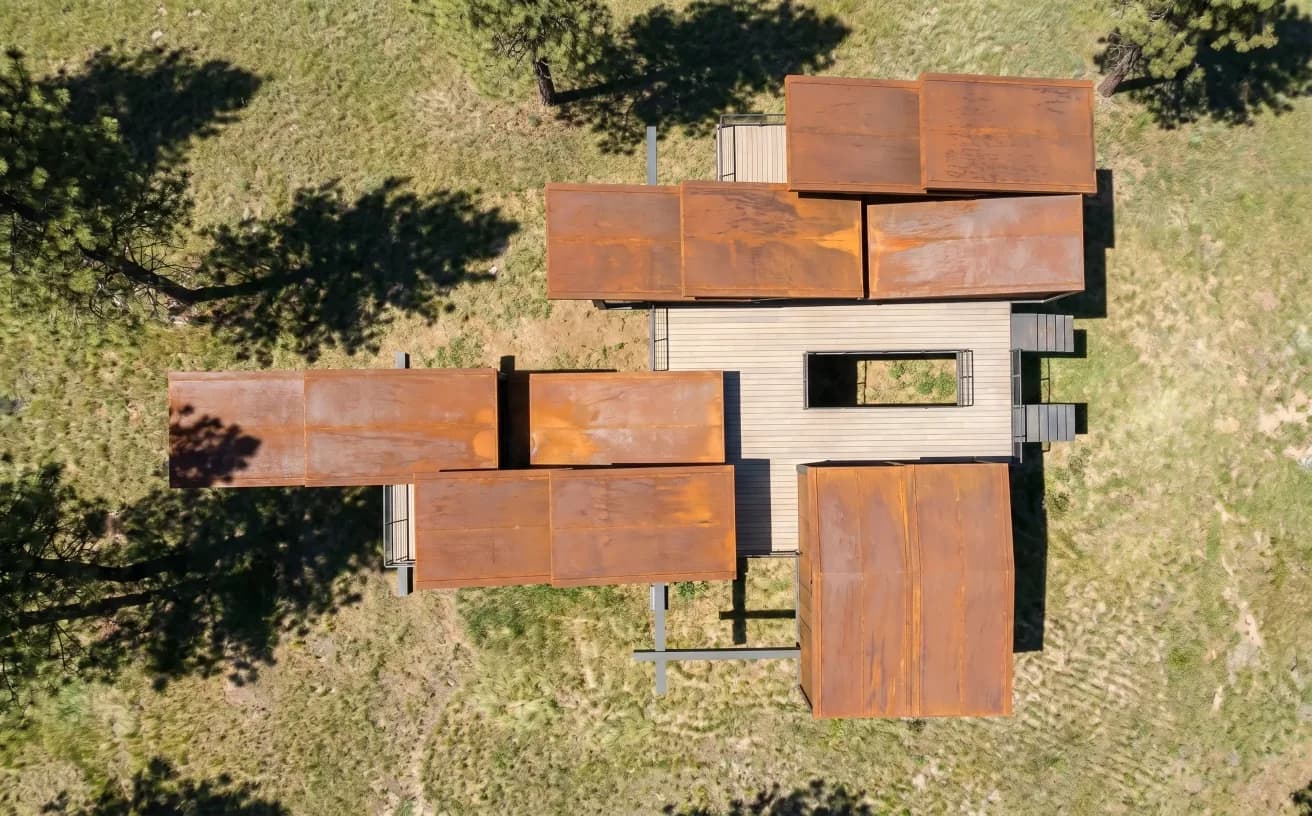 Top-down view of a cluster of modular cabin volumes on a grassy site.